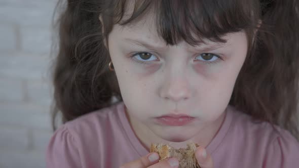 A hungry child eats bread. alt