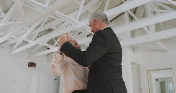 Caucasian senior couple spending time together dancing in a ballroom