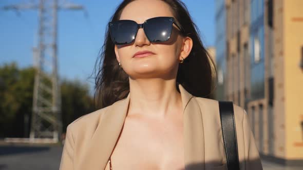 Portrait of Beautiful Lady in Sunglasses Walking at Sidewalk