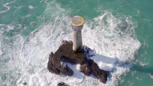 Lighthouse on a Rock in the Ocean with Crashing Waves and a Helipad