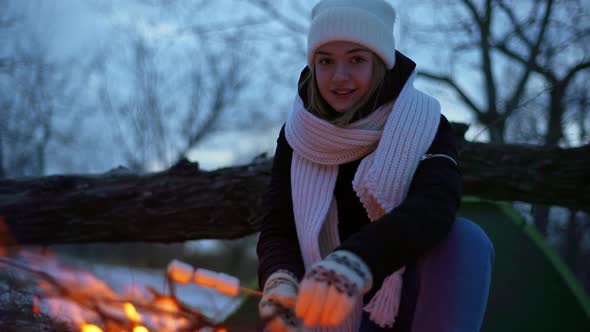 Portrait of Happy Caucasian Woman Smiling While Sitting Near Campfire Outdoor and Frying