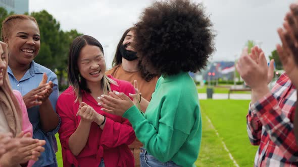Diverse young friends clapping hands celebrating together outdoor