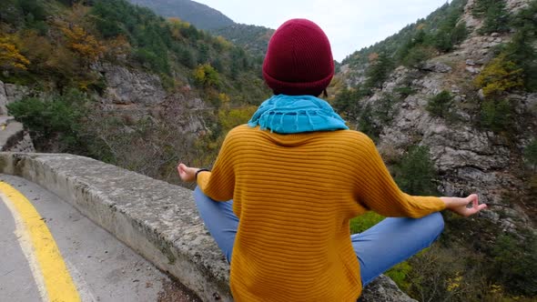 a Woman in a Yellow Sweater Enjoys the Silence of the Mountains