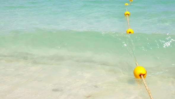 Yellow Buoy with Wave on the Beach 