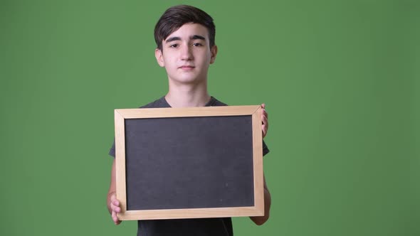 Young Handsome Iranian Teenage Boy Against Green Background