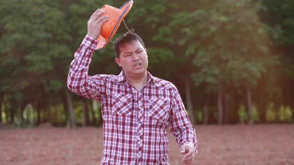 Asian farmer getting tired from work at farm