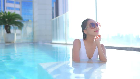 Young asian woman enjoy around outdoor swimming pool for leisure