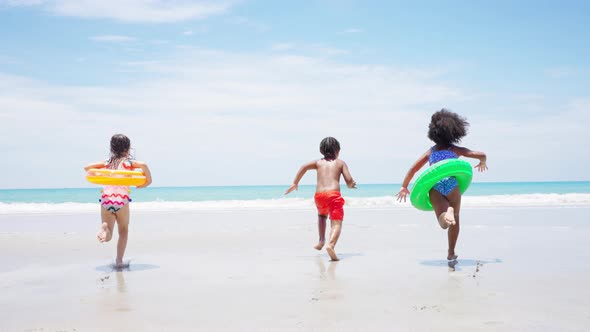 4K Group of Diversity children playing on tropical beach together on summer vacation at the sea