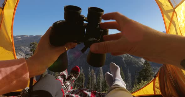 Two People in a Camping Tent, Set in Yosemite National Park, Pass Binoculars To Each Other. USA