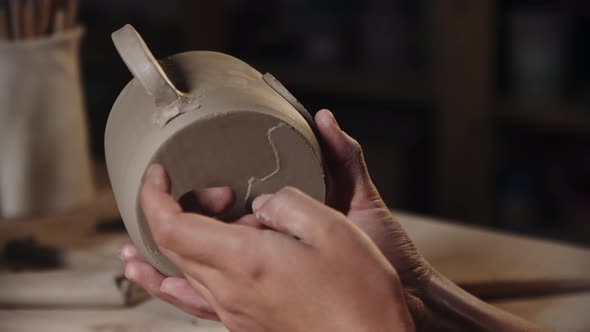 Woman Potter Chipping Away the Excess of the Clay From the Bottom of a Cup