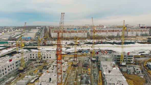 Construction in Progress Buildings with Cranes Against Town