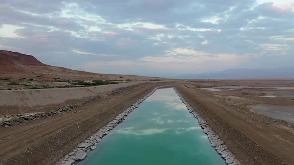 Israel, Turkiz color channel of water by the Deadsea sky reflection, Drone Shot Forward and upment.