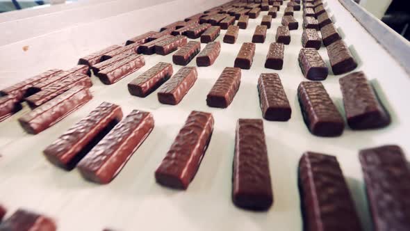 Conveyor Belt with Plenty of Glazed Sweets Moving Through It