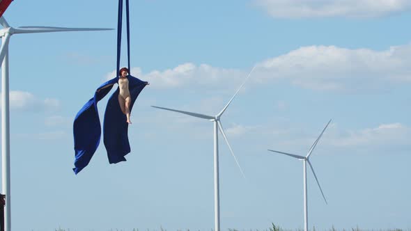 Wind Turbine and Blue Sky in the Background of a Young Woman Flying, Fabric