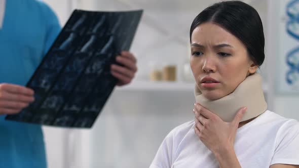 Sad Female Patient Feeling Uncomfortable in Cervical Collar, Doctor Examination