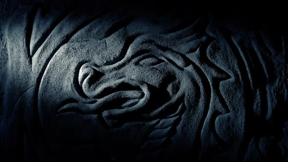 Torch Lights Up Dragon Carving On Cave Wall