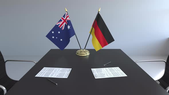 Flags of Australia and Germany and Papers on the Table alt