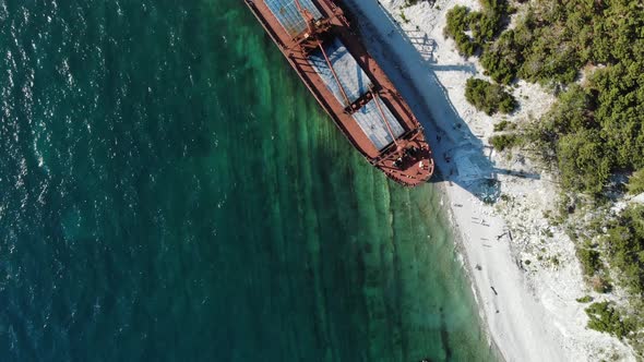 Top-down View of a Sunken Ship Aground. A Beautiful Huge Dry Cargo Ship of Red Color Has Long Been