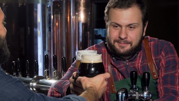 Friendly Bartender Clinking Glasses with Customer, Drinking Beer