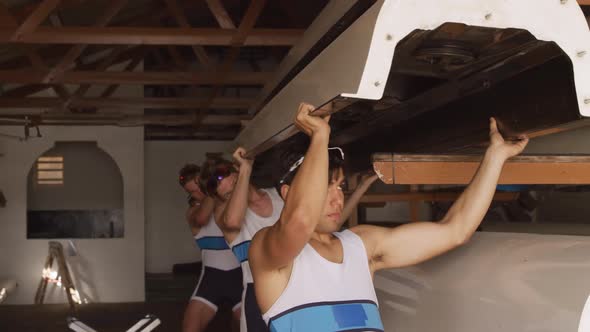 Male rower team carrying the boat above their head