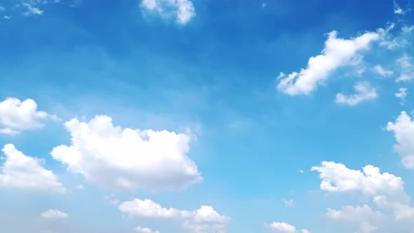 White puffy clouds and blue sky time-lapse with long second duration for background and graphics in