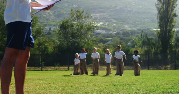 Children playing a sack race in park