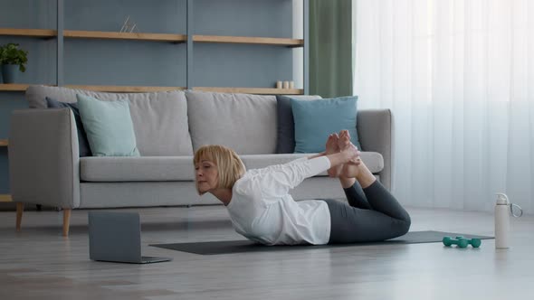 Senior Woman Doing Stretching Exercise Lying On Stomach At Home