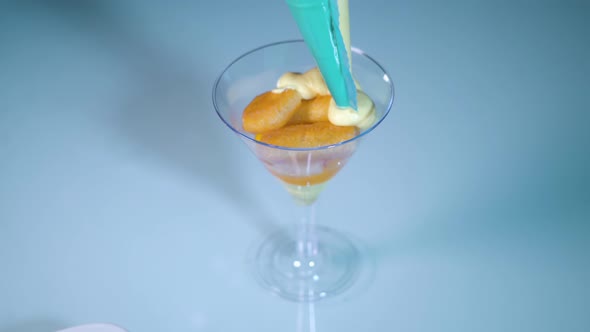 Cream is Placed Over Ladyfingers in the Plastic Chalice