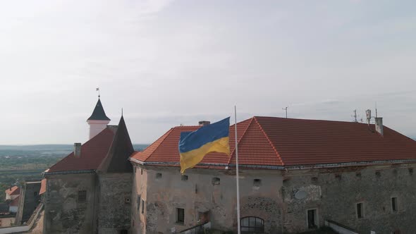 Ukrainian Flag Flies on Wall of an Ancient Medieval Castle in Small European City