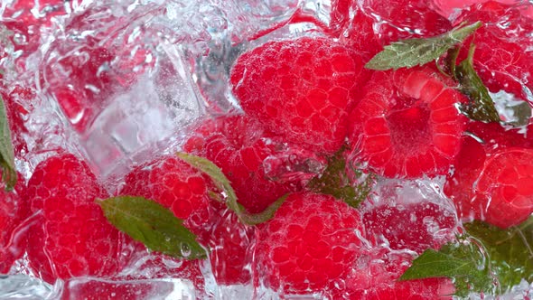 Super Slow Motion Shot of Pouring Water on Raspberries and Ice Cubes in Glass at 1000 Fps