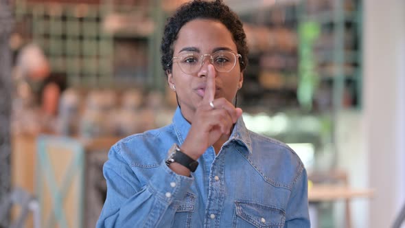 Portrait of Serious African Woman Putting Finger on Lips, Quiet Sign 