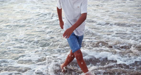 a Boy Dances in the Waves of the Sea Latin American Dances