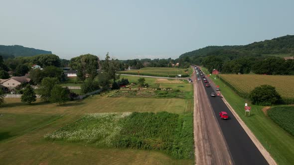 Drone view over rural highway construction screen with alternating traffic and farm fields.