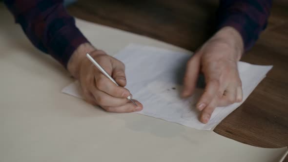 The Process of Manufacturing a Leather Wallet Handmade. The Wizard Makes a Mark on the Leather Bark