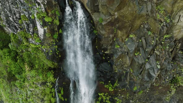Close-up vertical drone ascent down Veu da Noiva waterfall in Seixal, Madeira