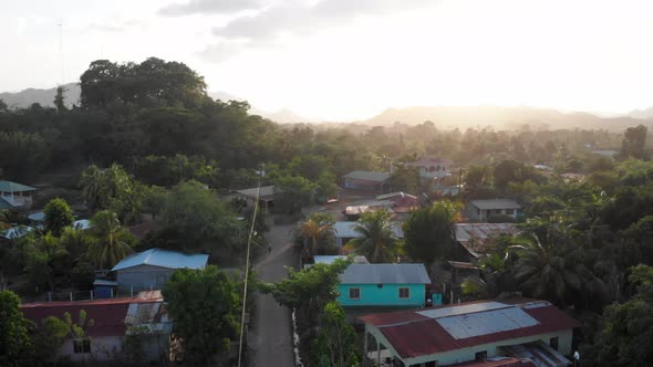 A drone shot of the late afternoon sun shining over a small Central American village