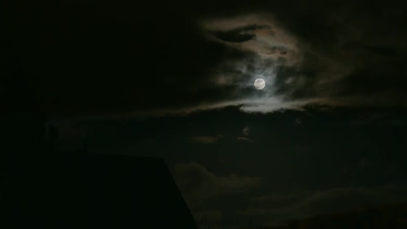 Cloudy dark sky with a shiny full moon in East Berlin, Germany