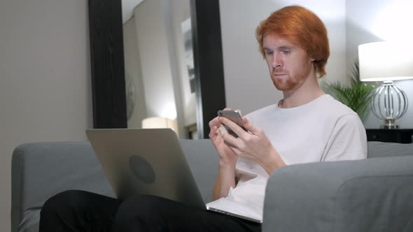 Redhead Man Using Smart Phone for Browsing