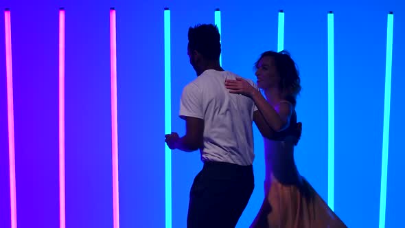 Ballroom Dancers Practice Salsa Dance Elements in the Studio Against a Backdrop of Bright