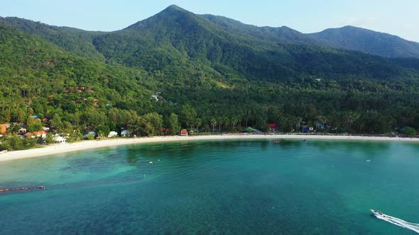 Paradise bay, calm clear water of turquoise lagoon with coral reefs on tropical island with green ve