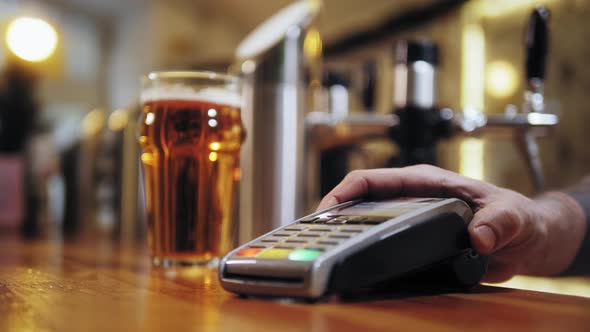 Buying Beer and Paying By Smartwatch Via Terminal Closeup