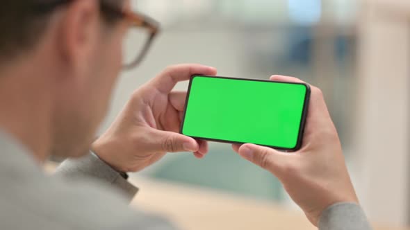 Middle Aged Man Looking at Smartphone with Chrome Key Screen 