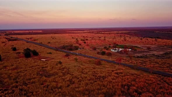 Aerial view of a road passing through the barren arid fields of Bahia at dusk