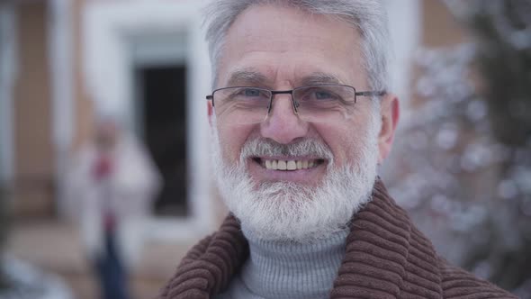 Close-up Face of Handsome Graceful Man in Eyeglasses Smiling at Camera. Senior Grey-haired Caucasian