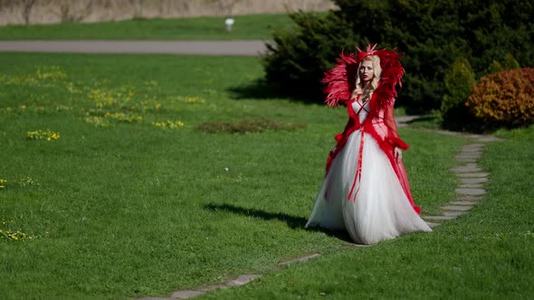 Amazing Beautiful Woman Dressed Extravagant Gown is Walking in Garden at Sunny Day Fairytale Concept