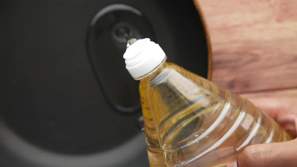 Pouring Sunflower Oil on a Cooking Pan Top View