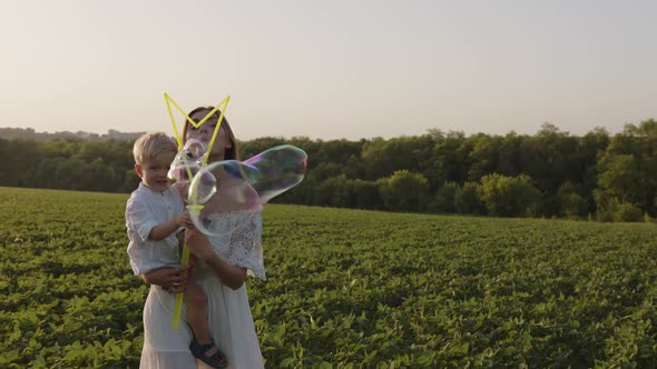 Beautiful Mother with Her Son Blow the Bubles Tj the Camera