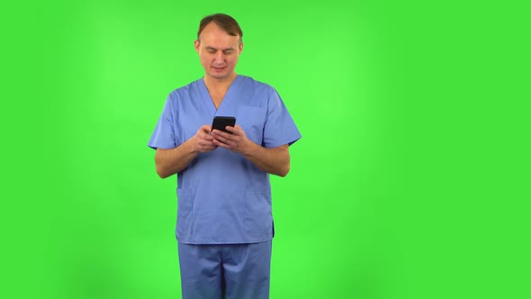 Medical Man Texting on Him Phone and Rejoice. Green Screen