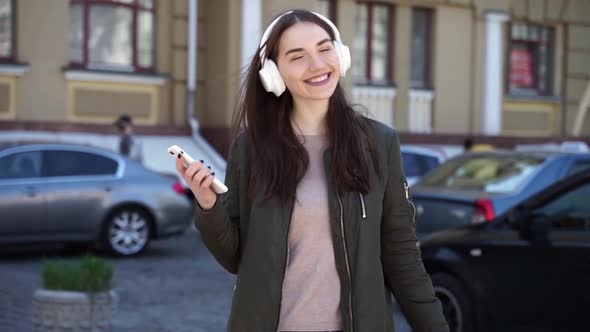 Beautiful, young woman in wireless headphones turns on your favorite music
