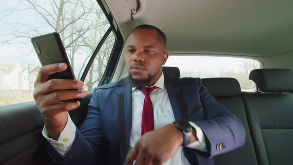 Positive Male Entrepreneur Typing Text Message on Phone in Car